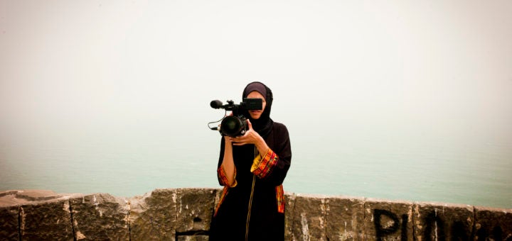 a woman, Safa Aden, with video camera