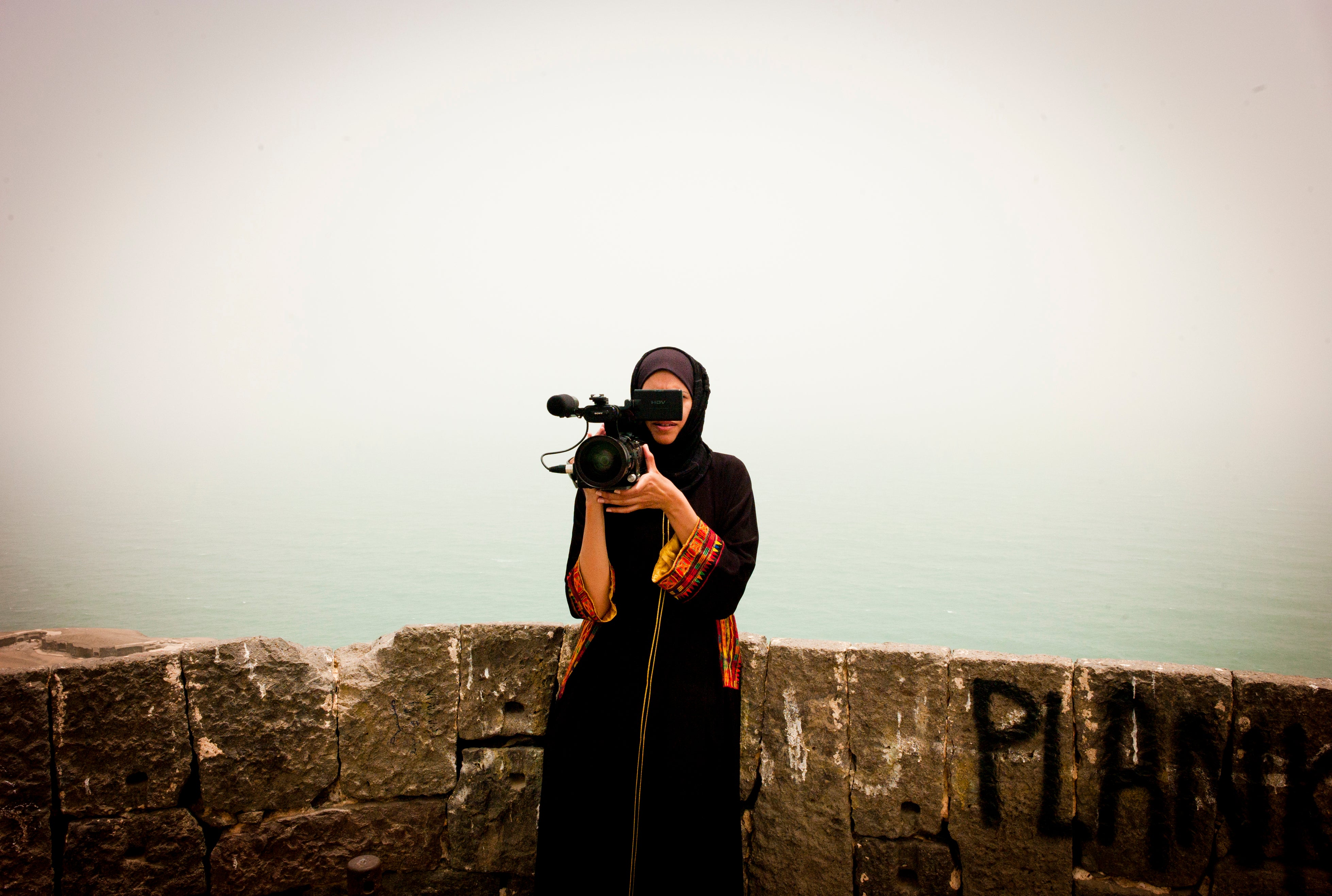 a woman, Safa Al Ahmad, with video camera